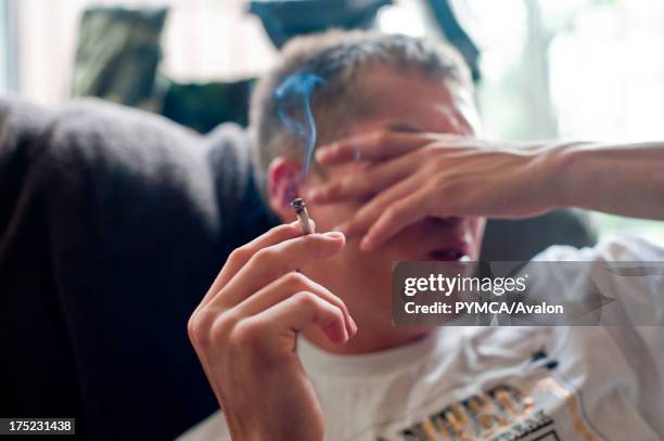Teenager with joint looking depressed.