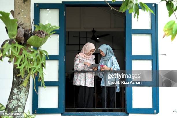 las mujeres asiáticas ven su progreso financiero en línea en casa - sharia fotografías e imágenes de stock