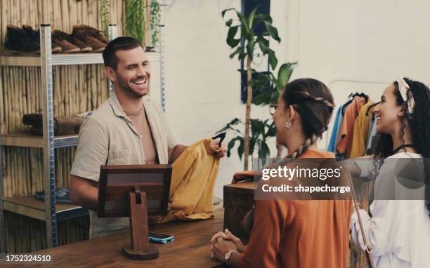 fashion, cashier and man in shop with customer, small business sales with friendly smile at pos and shopping. clothes, happy women at register in thrift store, retail payment, and people in boutique. - fashion store staff stock pictures, royalty-free photos & images