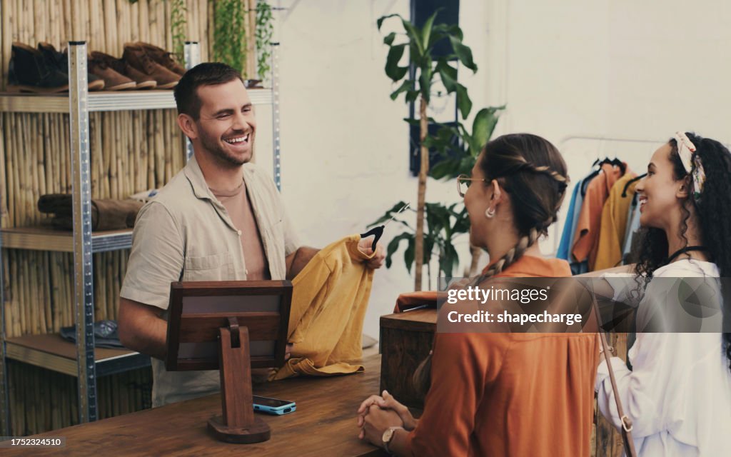 Fashion, cashier and man in shop with customer, small business sales with friendly smile at pos and shopping. Clothes, happy women at register in thrift store, retail payment, and people in boutique.