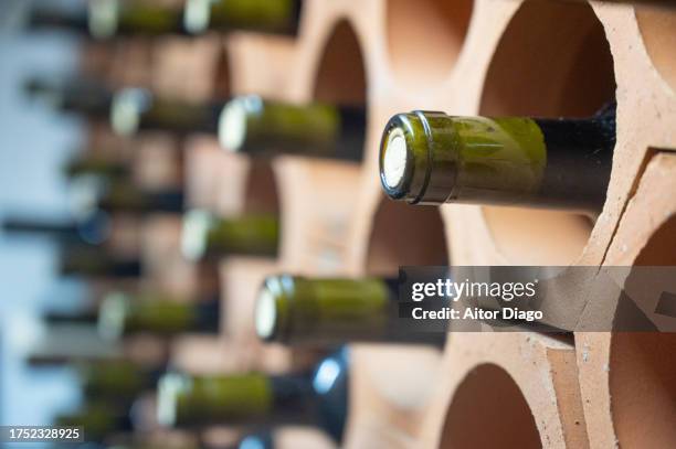 bottles of wine in a wine cellar. - wine bottle stock pictures, royalty-free photos & images