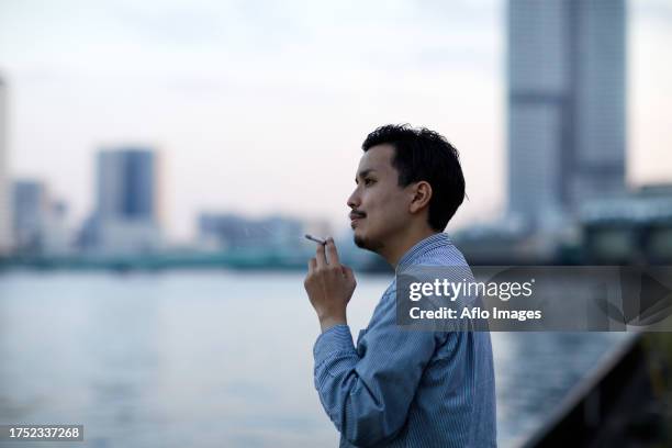 japanese man smoking outside - zigarettenpause stock-fotos und bilder
