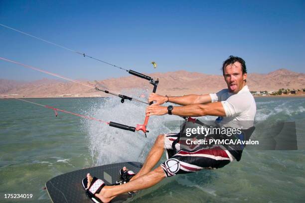 Kitesurfer pulls a face as he speeds past in Dahab's lagoon, a favourite hotspot for many wind related watersports, Sinai, EGYPT. .