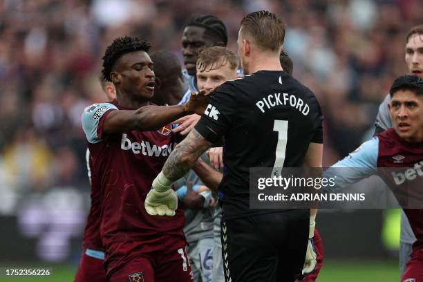 Everton's English goalkeeper Jordan Pickford and West Ham United's Ghanaian midfielder Mohammad Kudas are both booked after a clash during the...