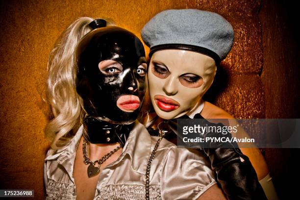 Two women with bright red lips and full face latex masks. Los Angeles USA 2009.