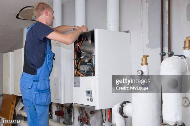 Heating and sanitary technician testing and adjusting a gas heater