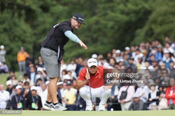 Collin Morikawa of the United States talks with his caddie before a putt on the 9th hole during the final round of ZOZO Championship at Accordia Golf...