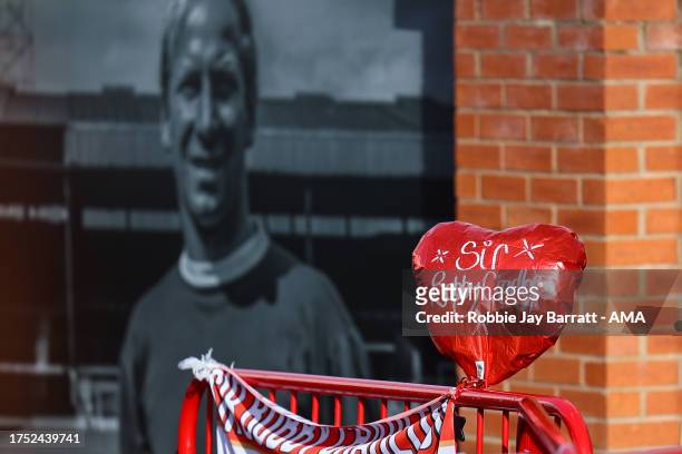 Balloon in honour of Sir Bobby Charlton is seen next to an image of him outside Old Trafford during the Premier League match between Manchester...