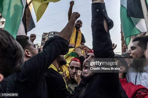 Hezbollah supporters carry the coffin of a Hezbollah militant killed by IDF while clashing yesterday in southern Lebanon yesterday, through the...