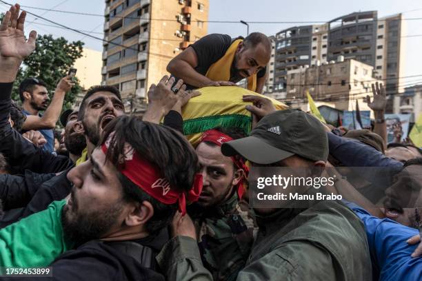 Hezbollah supporters carry the coffin of a Hezbollah militant killed by IDF while clashing yesterday in southern Lebanon yesterday, through the...