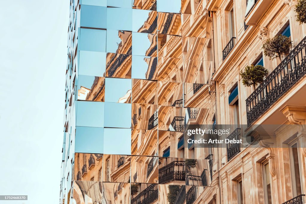 Surreal mirror building reflecting the Paris skyline like a puzzle in Champs Elysees.