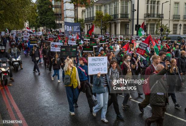 Pro-Palestinian protesters march with placards and flags at a demonstration against Israeli attacks on Gaza in central London, UK.