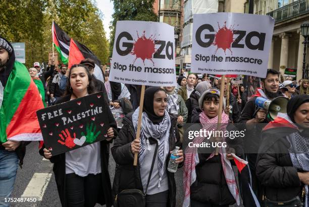 Pro-Palestinian Muslim women hold placards as they march at a major demonstration against Israeli attacks on Gaza in central London, UK.