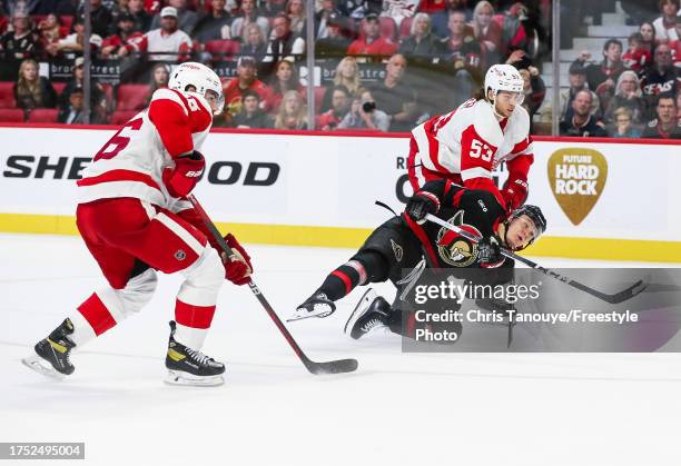 Tim Stützle of the Ottawa Senators battles for the puck with Moritz Seider of the Detroit Red Wings at Canadian Tire Centre on October 21, 2023 in...