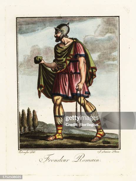 Funditor or slinger in the Roman army, ancient Rome. In galea helmet, cape, tunic, sagulum gregale or short trousers, caligae hobnail sandals, armed...