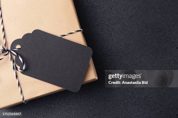 top view of gift box with black and white ribbon and blank label. black friday sale concept. - bid offer stock pictures, royalty-free photos & images