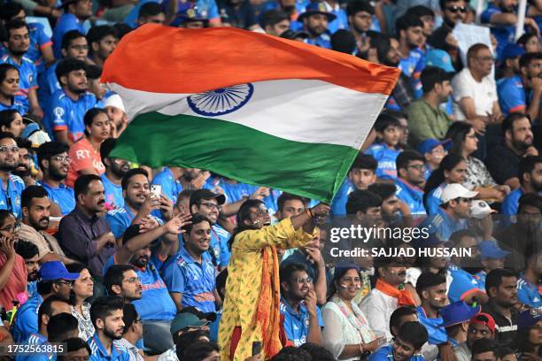 Fan waves India's national flag during the 2023 ICC Men's Cricket World Cup one-day international match between India and England at the Ekana...
