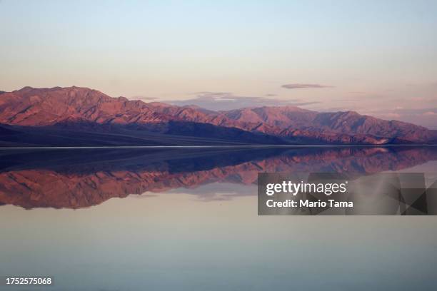 The sun rises beyond the sprawling temporary lake at Badwater Basin salt flats, which was caused by flooding in August from Tropical Storm Hilary, at...