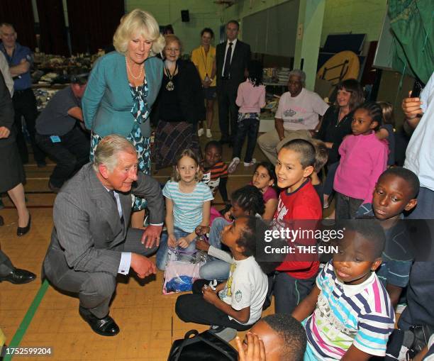 Britain's Prince Charles and Camilla, the Duchess of Cornwall speak with children during a visit to the Tottenham Green Leisure Centre in east...