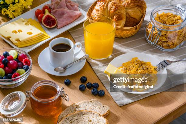 gesundes frühstück mit rührei, käse, schinken, kaffee, croissants und fruchtsaft - büfett stock-fotos und bilder