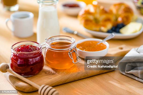 sweet food. jars of jam and honeyon breakfast table - jam stock pictures, royalty-free photos & images