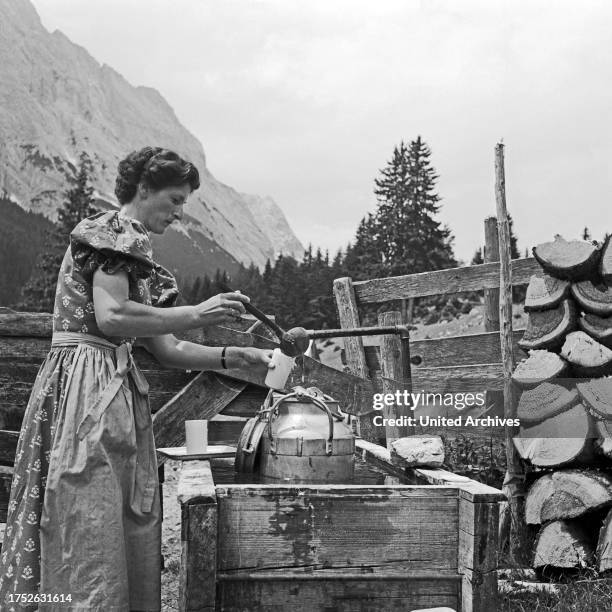 Woman taking some milk, Germany 1957.