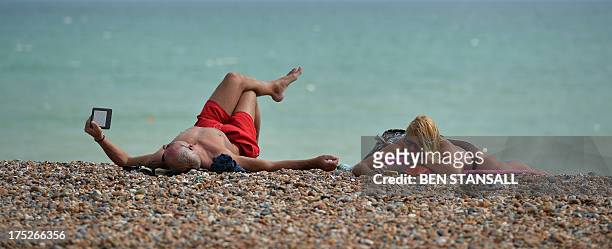 People relax in on the beach in Hove, on the south coast during hot weather on August 1, 2013. Temperatures in the south of England rose to over 33C...