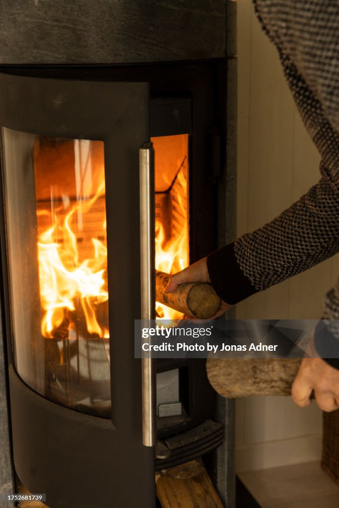 Putting in firewood in the stove