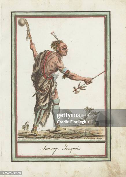 Warrior of the Iroquois Confederacy. In animal skin cloak, breechcloth, mitasses and moccasins, holding a pipe tomahawk and casse-tete or mace, with...