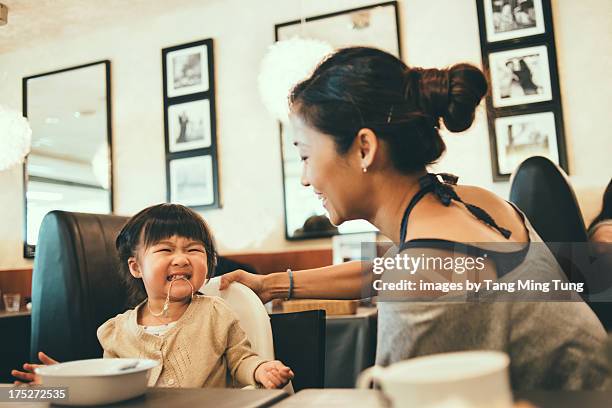 Young mom playing with toddler on dining table