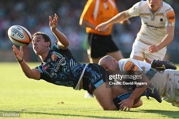 Luke Treharne of Exeter Chiefs off loads the ball as Paul Hodgson of Worcester Warriors tackles during the J.P. Morgan Asset Management Premiership...