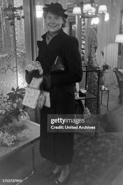 Woman doing her christmas shopping at a departement store, Germany 1930s.