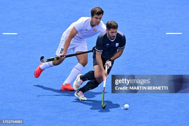 Argentina's Agustin Mazzilli is challenged by Peru's Manuel Barco during the field hockey men's team preliminary group A match 5 between Argentina...