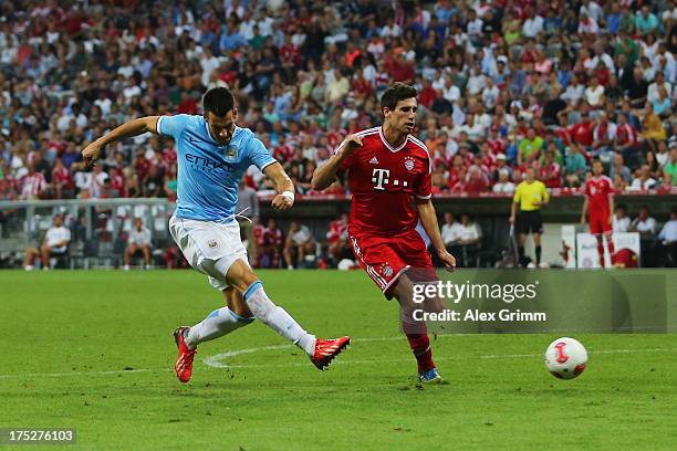 Alvaro Negredo of Manchester scores his team's first goal against Javier Martinez of Muenchen during the Audi Cup Final match between FC Bayern...