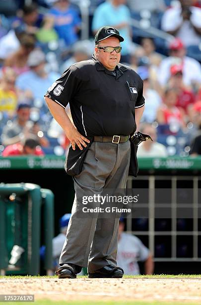 Home plate umpire Wally Bell rests during a break in the game between the New York Mets and the Washington Nationals at Nationals Park on July 26,...