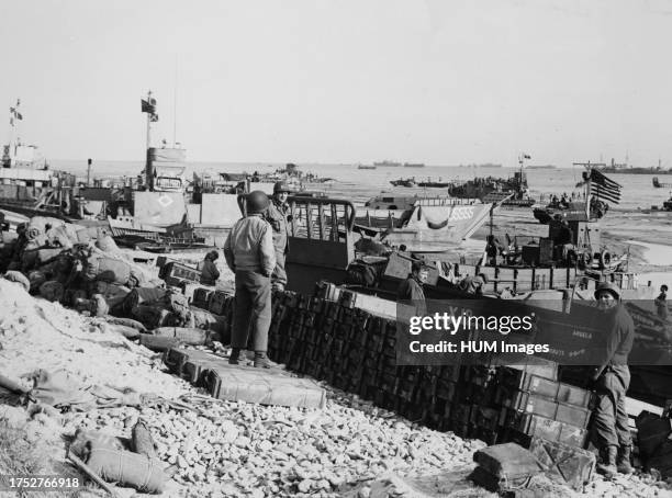 LCTs at invasion beach near Normandy France with LCIs and smaller landing craft off shore bring in men and supplies ca. 1944.