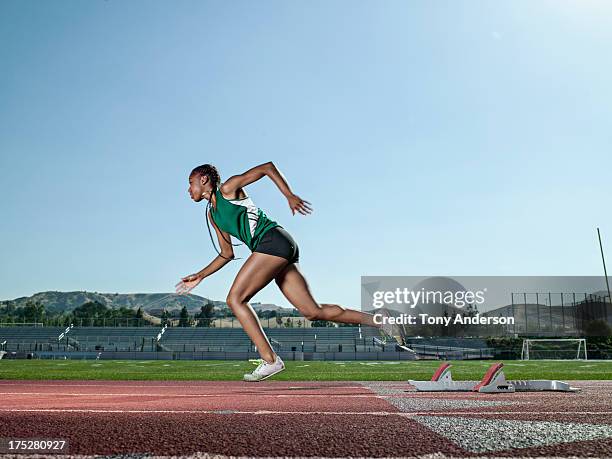 young woman track athlete starting from blocks - girl side view stockfoto's en -beelden