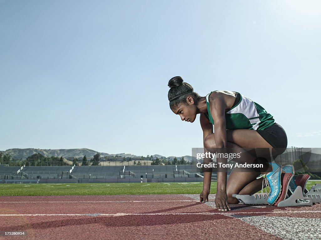 Young woman track athlete at starting block