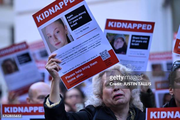 Poster showing the kidnapped Israeli Agam Goldstein-Almog is held up as people gather outside the Qatari Embassy in London on October 29 to demand...
