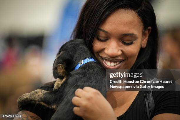 Kourtney Griffin nuzzles with a puppy as her sister-in-law looks for a pet during Petco Love's Mega Adoption Event on Saturday, Oct. 21 at the George...