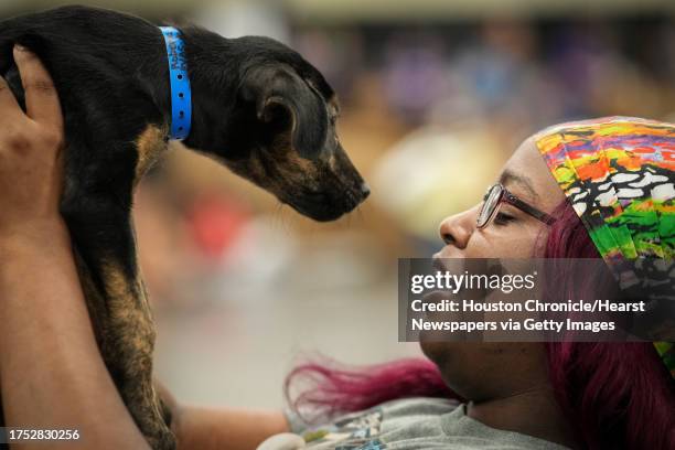 Joia Yarber looks at a puppy during Petco Love's Mega Adoption Event on Saturday, Oct. 21 at the George R. Brown Convention Center in Houston. She...