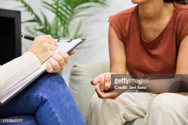 close-up of an unrecognisable sad patient talking about her problems with her therapist in a psychology session. - kinesist stockfoto's en -beelden