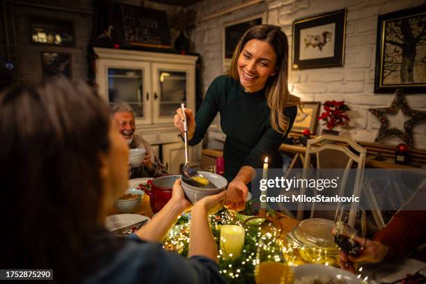junge frau serviert eine suppe während des weihnachtsessens - suppe stock-fotos und bilder