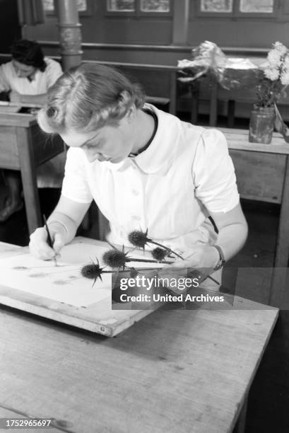 Trainees of a textile factory in Krefeld are designing new patterns for the textile production during drawing classes, Germany 1930s.