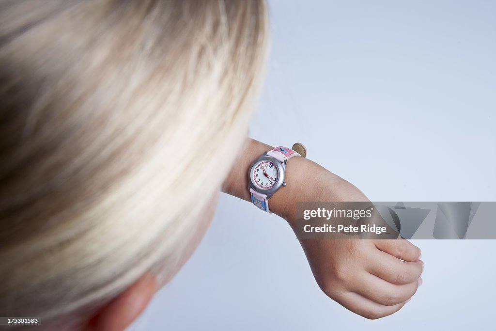 Young girl looking at her watch