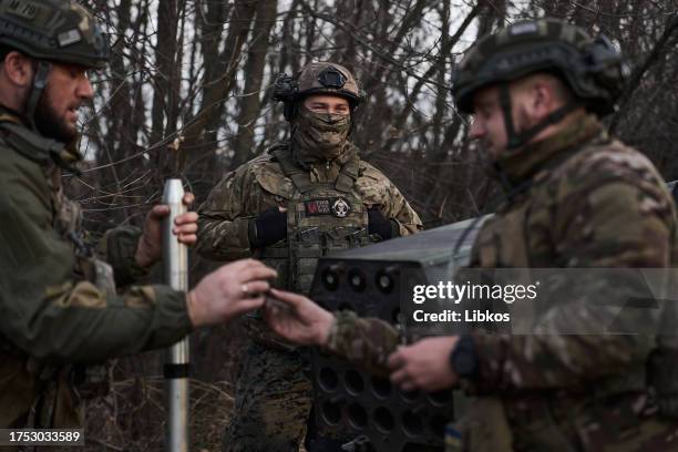 Ukrainian military personnel load ammunition to a launcher, as the Military special unit "Kurt & Company group" armed with homemade mini-MLRS fires...