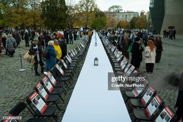 Signs with photos of victims are seen during a vigil in Warsaw, Poland on 29 October, 2023. Several hundred people joined a vigil in honour of the...