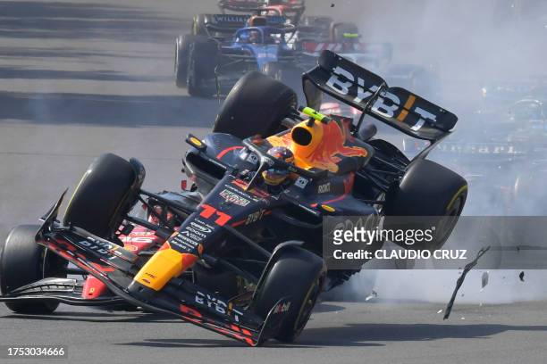 Red Bull Racing's Mexican driver Sergio Perez crashes with Ferrari's Monegasque driver Charles Leclerc at the start of the Formula One Mexico Grand...