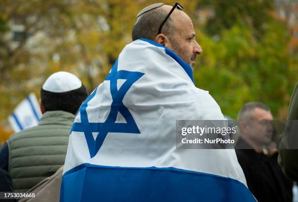 Man wearing an Israeli flag is seen during avigil in Warsaw, Poland on 29 October, 2023. Several hundred people joined a vigil in honour of the...