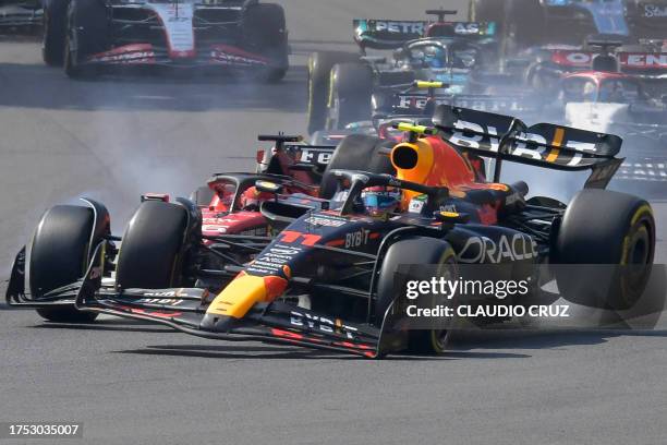 Red Bull Racing's Mexican driver Sergio Perez crashes with Ferrari's Monegasque driver Charles Leclerc at the start of the Formula One Mexico Grand...